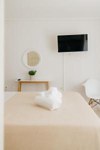 uma cama branca com uma pilha de toalhas em CACTUS - Blooming Garden Apartments em Kalamata