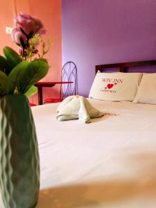 ein Schlafzimmer mit einem Bett mit einer Blumenvase in der Unterkunft WJV INN Canduman in Mandaue City