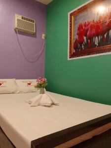 ein Schlafzimmer mit einem Bett mit einer Blumenvase darauf in der Unterkunft WJV INN Canduman in Mandaue City