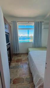ein Schlafzimmer mit einem Bett und einem großen Fenster in der Unterkunft angra dos reis, condomínio angra inn in Angra dos Reis