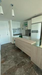 a kitchen with white cabinets and a wooden counter top at angra dos reis, condomínio angra inn in Angra dos Reis