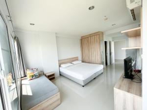 1 dormitorio con 1 cama y TV. en Des Res Hotel and Residence en Bangna