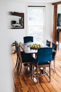 a dining room table with chairs and fruit on it at Naivasha Cottage in Deloraine