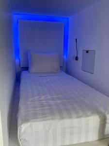 a bed in a room with a blue light at My Capsule Canggu in Canggu