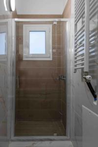 a shower with a glass door in a bathroom at Volos City Center 1 in Volos