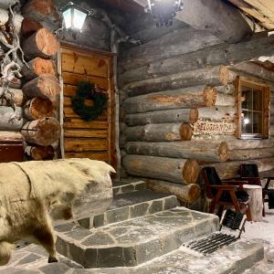 a log cabin with a fireplace in front of it at Kelogornitsa in Kittilä