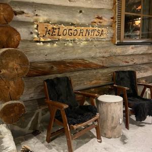 two rocking chairs and a sign on a log wall at Kelogornitsa in Kittilä