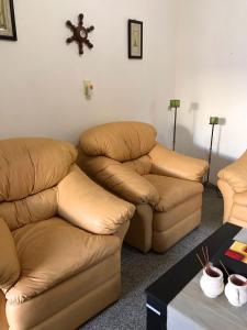 salon z 2 krzesłami i kanapą w obiekcie Urqu-Pacha Alojamiento w mieście Tinogasta