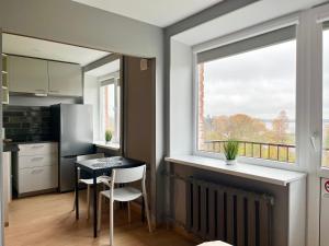 una cocina con una mesa pequeña y una ventana en Aizkraukle Penthouse apartment, en Aizkraukle