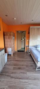 Habitación con 2 camas y pared de color naranja. en Ferienzimmer im schönen Erzgebirge en Neuhausen