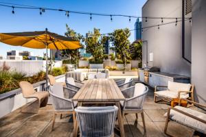 un patio con mesa, sillas y sombrilla en Modern Apartment Rentals en Los Ángeles