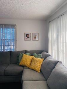 a living room with a gray couch with yellow pillows at Downtown home with Jacuzzi in Las Vegas