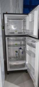 a refrigerator with its door open with a bottle of water at Posada Dakema in Cartagena de Indias