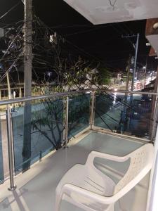 una silla blanca en la parte superior de un balcón en Posada Dakema en Cartagena de Indias