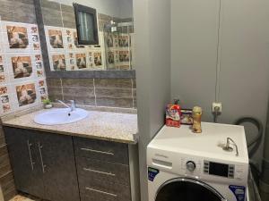 a bathroom with a washing machine and a sink at Pelaka Confort in Pamandzi