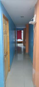 um corredor com um quarto com paredes azuis e uma porta em Posada Dakema em Cartagena de Indias