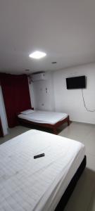 Habitación con 2 camas y TV de pantalla plana. en Posada Dakema en Cartagena de Indias
