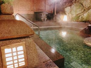 a bath room with a pool of water in a cave at KOUBOUNOYU NAGAOKA in Kona