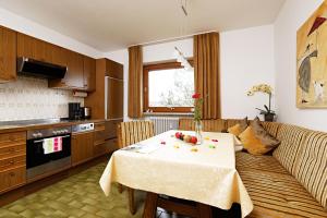 a living room with a table and a kitchen at Ferienwohnung Karin in Kierwang