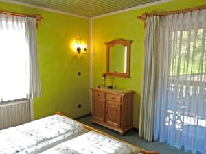 1 dormitorio con cama y espejo en la pared en Gästehaus Achenwinkel Ferienwohnung, en Ramsau