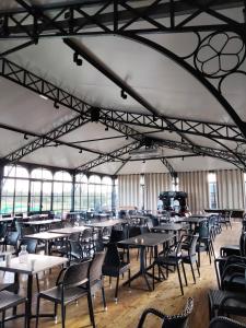 une salle à manger vide avec des tables et des chaises dans l'établissement Les papillons 441, à Litteau