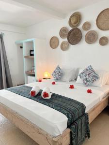 a bedroom with a large bed with red flowers on it at 7SEAS Cottages in Gili Islands