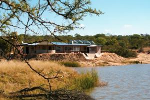 a house on a hill next to a body of water at Casa de la Presa 4 in Polokwane