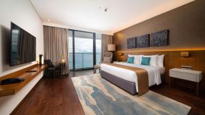 a hotel room with a large bed and a television at The Reef Island Resort Mactan, Cebu in Mactan