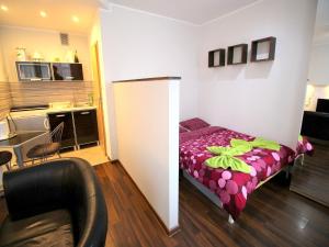 a small room with a bed and a kitchen at Happy Apartments - Economy in Wrocław