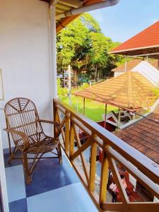 a chair on a balcony with a view of a yard at Fort Bridge View in Cochin