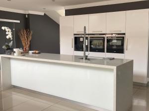 a kitchen with white cabinets and a counter top at Treklaer Lodge in Hartenbos