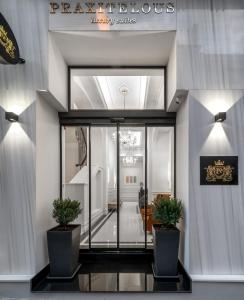 een lobby met twee potplanten in een gebouw bij Praxitelous Luxury Suites in Athene