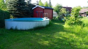 a hot tub in a yard with a red shed at Historische Ferienwohnung in Spremberg