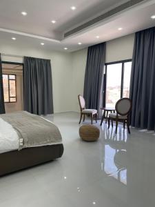 1 dormitorio con cama, sillas y mesa en Lammah chalet en Mascate
