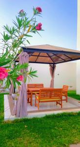 two benches under an umbrella in a yard at Lammah chalet in Muscat