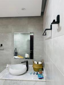 ein Bad mit einem Waschbecken und einem Spiegel in der Unterkunft Lammah chalet in Muscat