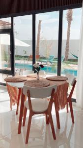 Lammah chalet في مسقط: طاولة وكراسي مطلة على المسبح