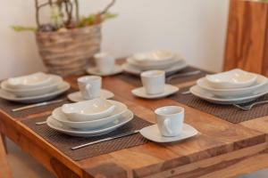 a wooden table with white plates and cups on it at Appartement Strandläufer mit Südbalkon by Unsere Urlaubszeit in Binz