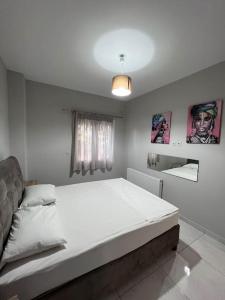 1 dormitorio con 1 cama blanca grande en una habitación en Comfy big apartment in Athens, en Atenas