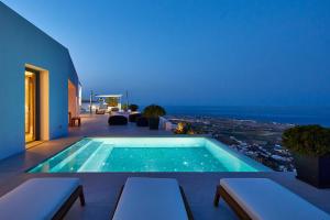 a swimming pool with a view of the ocean at Kamini Santorini Villas in Pirgos