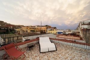 un divano bianco e una sedia sul tetto di Stunning View with 3 Terraces near DANTE SQ! By HouseinNaples a Napoli