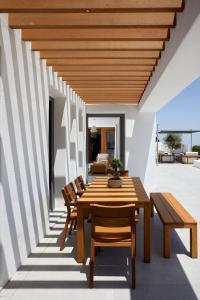 a dining room with a wooden table and chairs at Kamini Santorini Villas in Pirgos