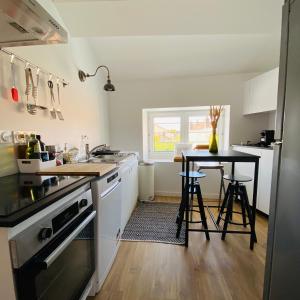 a kitchen with a sink and a table with stools at La Dormance in Beaune