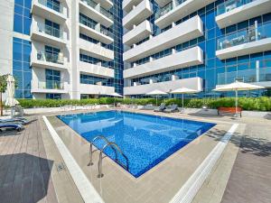a swimming pool in front of a building at Fully Furnished Studio - 70m from Metro Station in Dubai