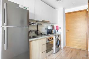 a kitchen with a refrigerator and a washer and dryer at Fully Furnished Studio - 70m from Metro Station in Dubai