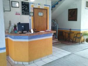 a restaurant with a counter and a table and stairs at Hotel Sarabi in Barra de Navidad