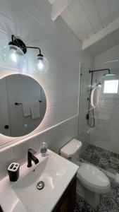 a bathroom with a sink and a toilet and a mirror at Treehouse in Tamanique