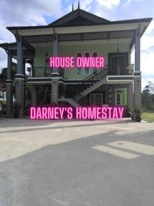 una grande casa con un cartello rosa davanti di Darney's Homestay Kg Bangau Tanjung a Temerloh