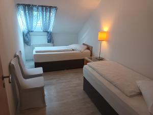 Habitación pequeña con 2 camas y ventana en 3 Zimmerwohnung optimal für Monteure en Reutlingen