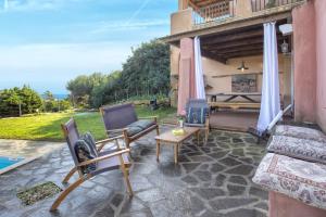 a patio with a couch and chairs and a fireplace at Villa Sa Pintadera private pool in Stintino